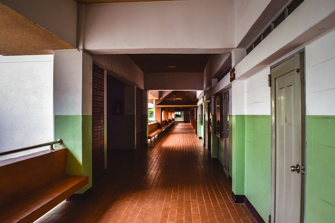 Empty bright classroom with large windows, tables and flipcharts