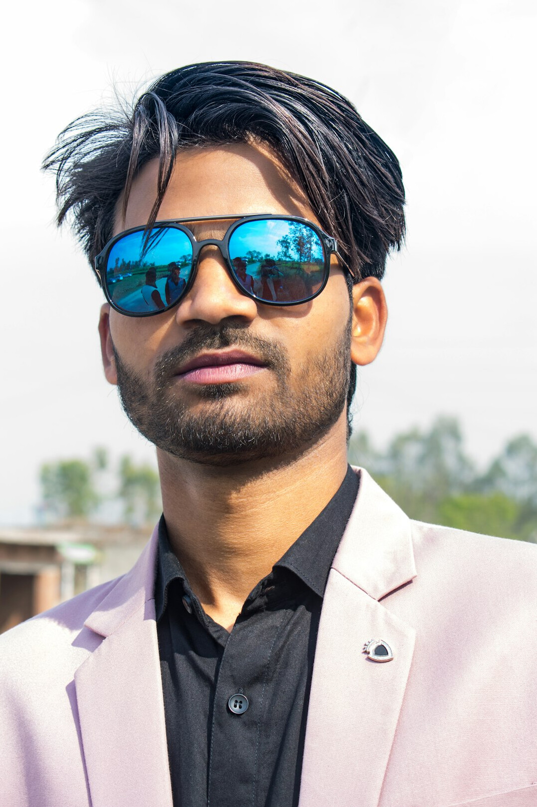 Portrait of a young man with a beard and glasses wearing a casual blazer